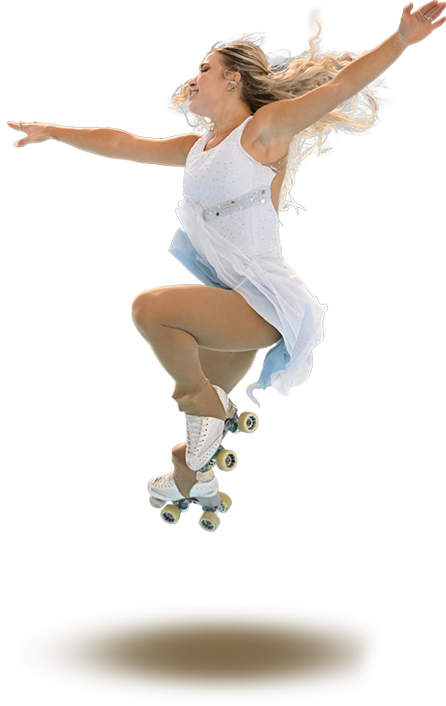 A woman, Mercedes Carascossa, wearing a white dress and roller skates performs a stag jump.